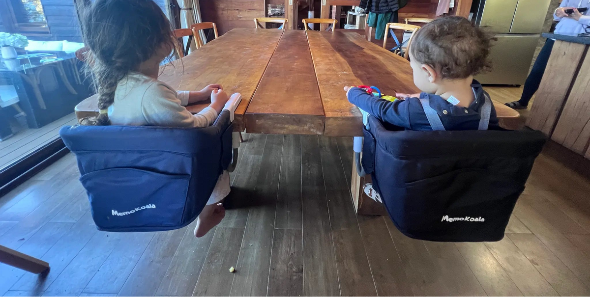 Dos niños con sillas HookOn MemoKoala en mesa de comedor - silla portátil familias chilenas