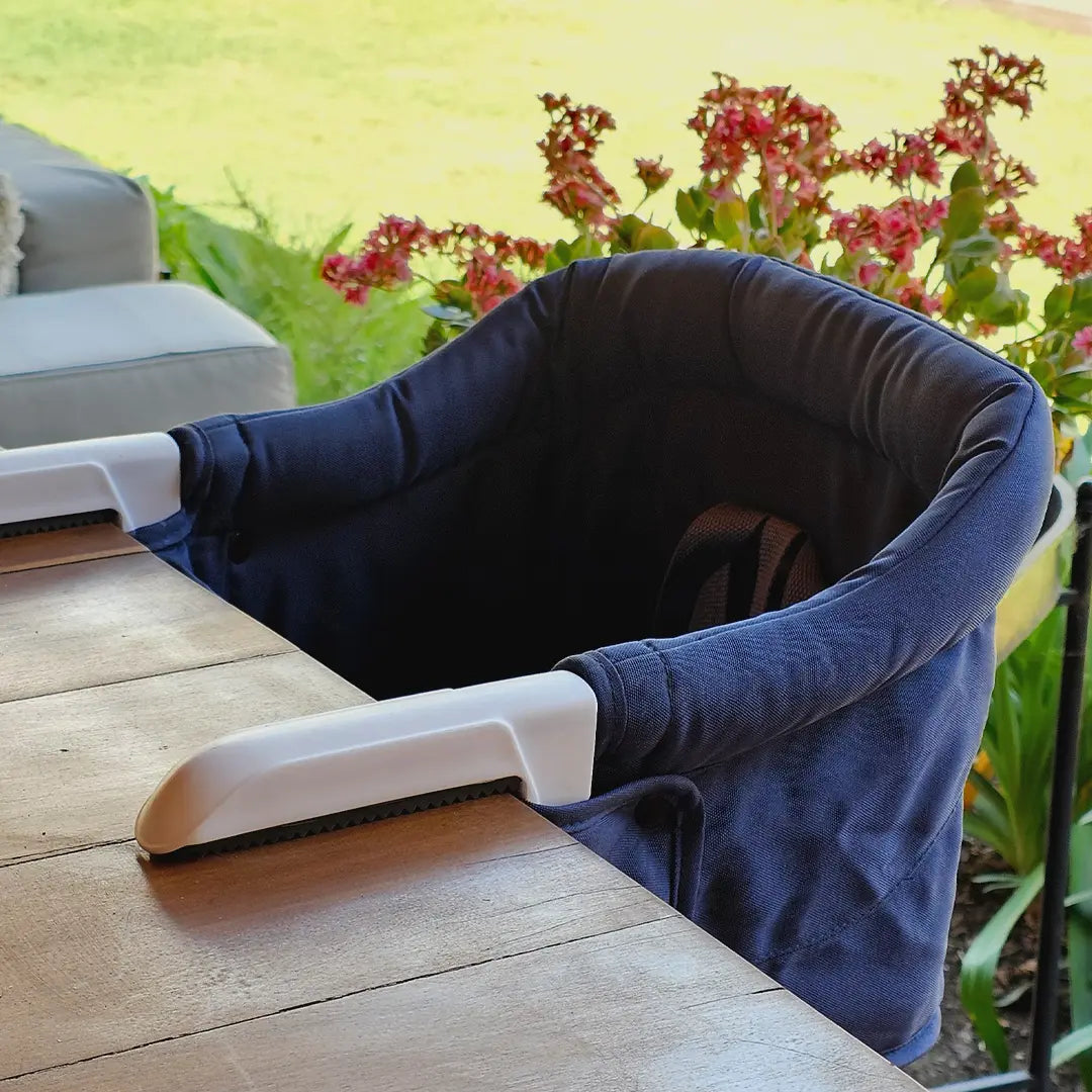 Silla portátil HookOn azul MemoKoala instalada en mesa - para bebés desde 6 meses a 3 años