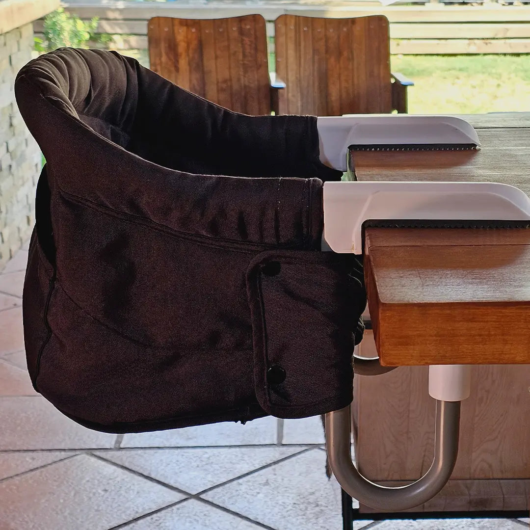 Silla HookOn negra MemoKoala instalada en mesa exterior madera - silla portátil bebé Chile